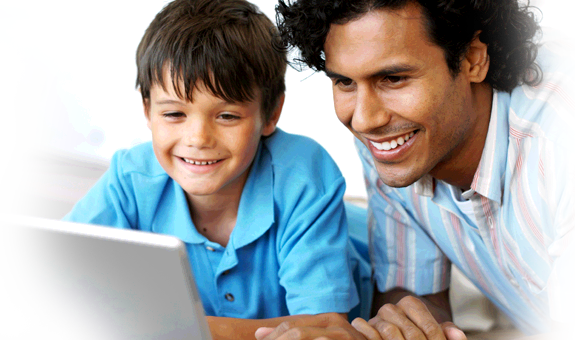 man and child looking at computer screen