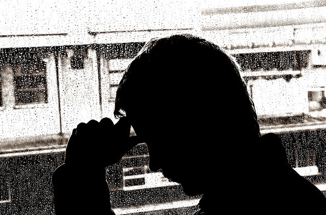 backlit man against rainy window