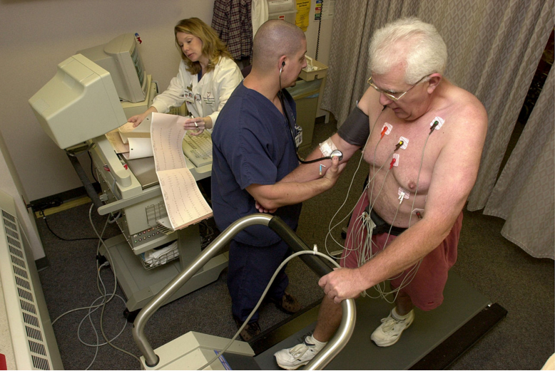 doctors performing a stress test while a man walks on a treadmill